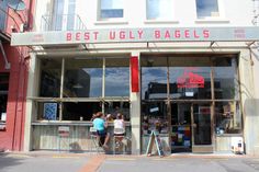 two people are standing in front of the best ugly bagels store, which is closed for business