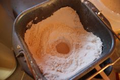 a metal pan filled with flour on top of a stove