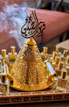 a golden crown sitting on top of a wooden table next to bottles of perfumes