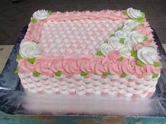 a pink and white cake sitting on top of a table