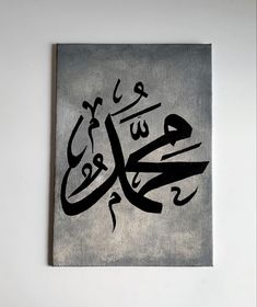 an arabic calligraphy is displayed on a white wall with black writing in the middle