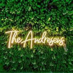 the word'the goddess'is lit up in front of green plants and foliage