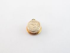 a small gold coin sitting on top of a white surface