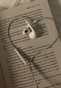 an open book with headphones laying on top of it