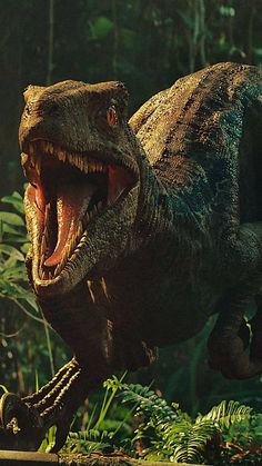 an image of a dinosaur that is running in the forest with it's mouth open