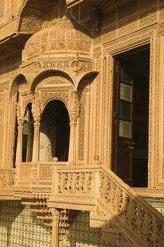 an intricately carved building with steps leading up to the door and window sill