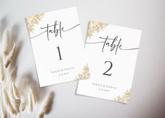 two place cards with gold leaves on them