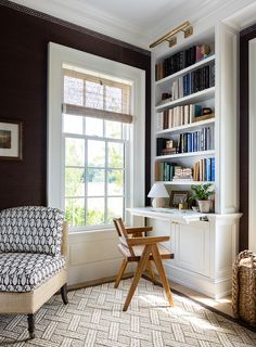 a living room filled with furniture and bookshelves next to a large open window