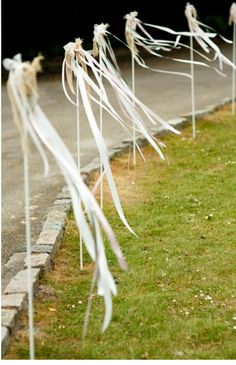 several white ribbons tied to the side of a road