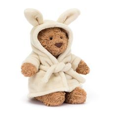 a brown teddy bear wearing a white robe and bunny ears on it's head