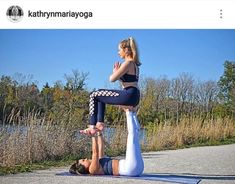 two women doing yoga poses on their stomachs in front of a lake and trees