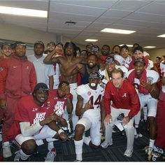 the football team is posing for a photo in their locker room with coaches and players