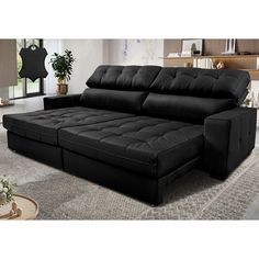 a black couch sitting on top of a rug in a living room