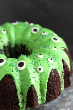 a chocolate cake with green frosting and googly eyes