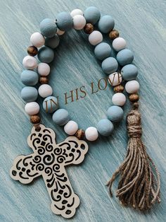 a bracelet with an ornate cross and tassel on it, next to the words in his love