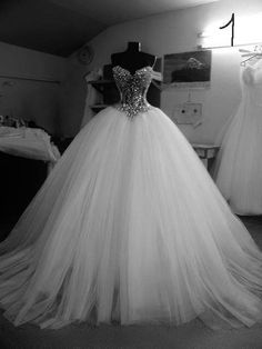 a white wedding dress with silver sequins on the top and bottom, in front of a mannequin