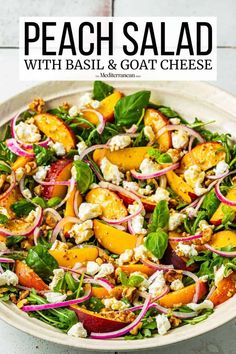 a white bowl filled with salad topped with peaches and feta cheese on top