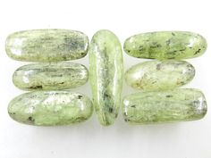 several green oval shaped rocks on a white surface