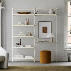 a living room filled with white furniture and shelves next to a wall mounted painting on the wall