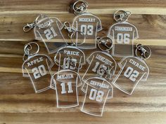 six keychains that have been cut out to look like football jerseys with numbers on them