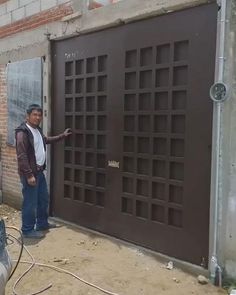 a man standing in front of a garage door with his hand on the side of the door