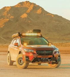 a car with lights on driving in the desert