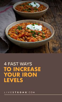 two bowls filled with beans and sour cream on top of a wooden table next to a napkin