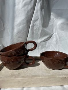 three brown cups sitting on top of a table