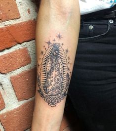 a woman's arm with a tattoo on it that has an image of the virgin mary