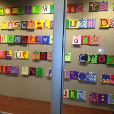 the wall is decorated with many different colored paper letters and numbers on each letter,