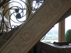 an ornate stair case next to a window