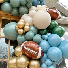 a balloon arch with footballs and balloons attached to it