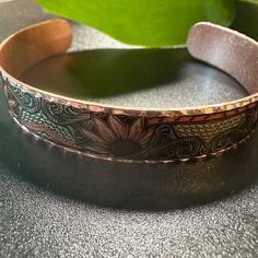 Expertly crafted by hand, the Handmade Copper Native Sunflowers Narrow Bracelet is a stunning piece that features intricate sunflower designs. Made from high-quality copper, this bracelet is not only beautiful but also durable. Elevate your style with this unique and elegant Floral Sunflowers Cuff Bracelet. Narrow Cuff Check out my other listings for matching Wide Cuff Sunflowers Bracelet & Matching Dangle Earrings Handmade Copper Bracelets As Gift, Traditional Decorative Bracelets For Gifts, Traditional Decorative Bracelets As Gift, Bohemian Sunflower Jewelry As Gift, Bohemian Sunflower Design Jewelry As Gift, Bohemian Sunflower Jewelry For Gift, Bohemian Flower Cuff Bracelet Handmade, Handmade Bohemian Flower Cuff Bracelet, Traditional Hand Tooled Bracelets As Gift