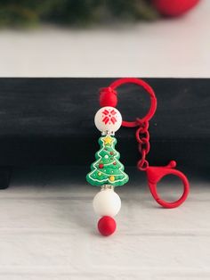 a keychain with a christmas tree on it and a ball attached to it