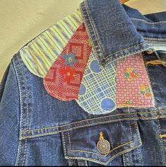 three pieces of fabric are attached to the back of a jean jacket