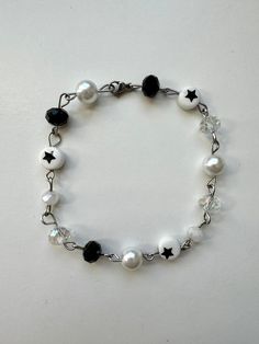 handmade black and white bracelet made with love ♡ made with glass beads, pearl beads, a stainless steel lobster clasp, and stainless steel silver wire.  CARE INSTRUCTIONS - please keep away from perfumes, oils, creams, and water  - avoid tugging or pulling on jewelry SOCIALS - instagram @butterflyinbloomco - tiktok @butterflyinbloomco dm if you have any questions or if you are interested in a custom order!  not responsible for lost or damaged mail Trendy White Bracelets With Beaded Chain, Trendy White Beaded Chain Bracelets, Handmade White Beaded Metal Bracelets, Handmade White Beaded Metal Bracelet, Handmade White Pearl Metal Bracelet, Handmade White Metal Pearl Bracelet, White Metal Bracelets With Round Beads, White Beaded Metal Crystal Bracelet, White Metal Pearl Bracelet With Round Beads