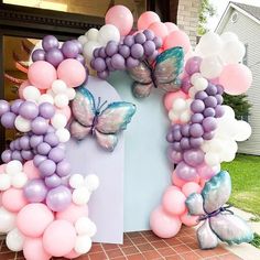 a bunch of balloons that are in the shape of a house with butterflies on it