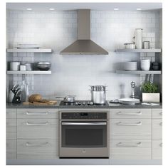 a stove top oven sitting inside of a kitchen next to white cupboards and shelves