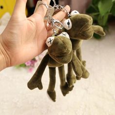 a person holding onto two stuffed animals with keys in their hands on a white carpet