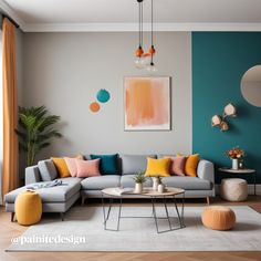 a living room with blue walls and yellow pillows on the couch, coffee table and ottoman