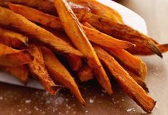 some very tasty looking french fries on a white plate with seasoning sprinkles