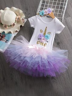 Perfect for first birthday celebrations, this outfit combines whimsy and charm to make her big day memorable. Features a beautifully designed unicorn print on the top, complete with a golden horn and sweet eyelash details. The multi-colored tulle tutu skirt is adorned with pastel flowers, adding a touch of grace and playfulness. Crafted with soft, breathable materials to ensure she stays comfortable throughout the celebrations. Designed for convenience with a stretchable neckline and snap closures for quick changes. Unicorn Dress Baby, Baby Tutu Dresses, Baby Birthday Dress, Skirt Tutu, Baby Party Dress, Infant Clothes, First Birthday Dresses, Birthday Unicorn