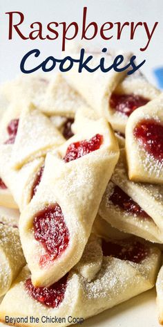 small pastries are piled up on a plate with powdered sugar and jelly toppings