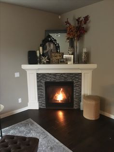 a living room with a fire place next to a mirror on the fireplace mantel