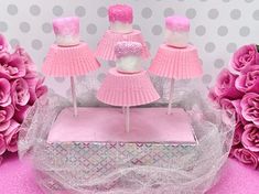 there are pink cupcakes on the cake stand