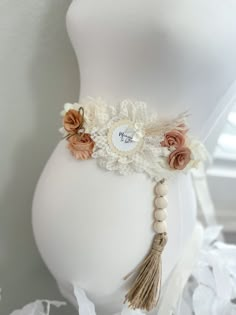 a white mannequin with flowers and tassels on it's waist