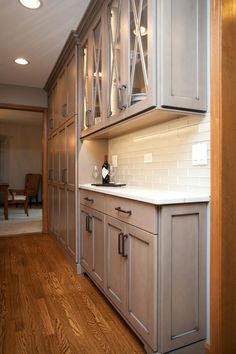 an empty kitchen with wooden floors and cabinets