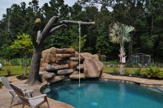 a backyard with a pool and rock waterfall