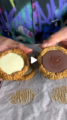 two people holding peanut butter and chocolate covered cookies