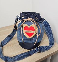 Express your love for the planet with our recycled denim and vegan catus leather bags. Each bag is a statement for sustainability, crafted from recycled denim/vegan leather with a unique twist. Wear an accessory that makes a difference - chic, eco-friendly and with a message of love. Embrace sustainable fashion and add a standout piece to your collection. Discover our recycled denim "Old jean new style" and "Dream" bags now, and embrace a style with heart. Trendy Recycled Denim Bags For Daily Use, Trendy Recycled Denim Shoulder Bag For Everyday Use, Casual Upcycled Bags From Recycled Denim, Casual Upcycled Bags Made From Recycled Denim, Casual Upcycled Bags Made Of Recycled Denim, Trendy Recycled Denim Shoulder Bag For Daily Use, Casual Upcycled Recycled Denim Bags, Trendy Blue Recycled Denim Shoulder Bag, Casual Handmade Recycled Denim Shoulder Bag